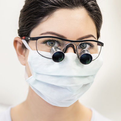 Dentist wearing loupes and a face mask
